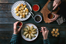 Family Or Friends Dinner With Dim Sum Gyozas Asian Fried Dumplings Set, Variety Of Sauces Served In Ceramic Plates With Chopsticks, Tea Cups And Teapot. Dark Blue Wooden Background. Flat Lay, Space