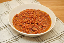 Baked Beans & Bacon Pieces Served In A White Bowl
