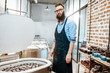 © rh2010 - Handsome man as a worker or business owner standing near electric ovens for ceramics at the pottery manufacturing