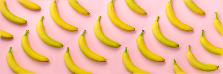 Wall Mural - geometric colorful fruit pattern. bananas over pink background. banner. top view. pop art design, cr