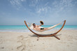 © serikbaib - man lying on a hammock resting on the beach