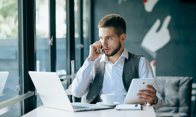 Wall Mural - Young handsome businessman conducting negotiations with investors. Electronic business. Alternative payment services. Management of the projects on freelance. Cryptocurrency. Blockchain. Trader.