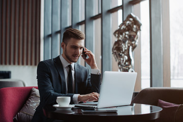 Wall Mural - Young handsome businessman conducting negotiations with investors. Electronic business. Alternative payment services. Management of the projects on freelance. Cryptocurrency. Blockchain. Trader.