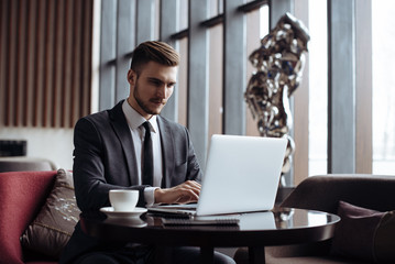 Wall Mural - Stylish young man calling by the phone to solve business problems. Online consultation by phone. Freelancer discussing the development and planning of his online project. Outsourcing. Mobile services.