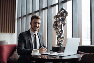 Wall Mural - Stylish young man calling by the phone to solve business problems. Online consultation by phone. Freelancer discussing the development and planning of his online project. Outsourcing. Mobile services.