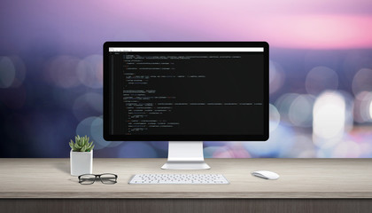 Wall Mural - concept of programming on a computer. work desk with computer display and text editor.