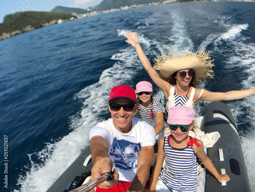 Fotomural family with children sailing on an inflatable motorboat in the sea