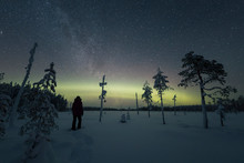 Person In Forest Under Northern Lights And Starry Sky