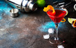 Classic alcoholic cocktail cosmopolitan with vodka, liqueur, cranberry juice, lime, ice and orange zest, dark bar counter background, night mood, space for text