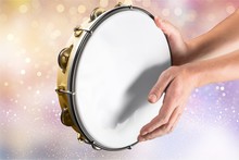 Female Hands Playing The Tambourine On Background