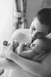 © Lea Csontos/Stocksy - Black and white portrait of a new mother holding and snuggling with her baby