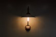 © Greg Schmigel/Stocksy - dim pendant lamp light hanging on an empty wall
