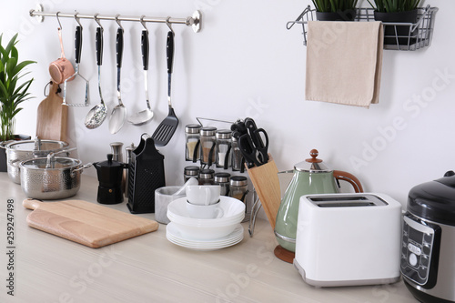 Cuadros en Lienzo Set of clean cookware, dishes, utensils and appliances on table at white wall