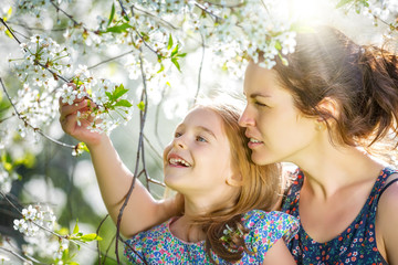 Mother and daughter in spring cherry blossom park