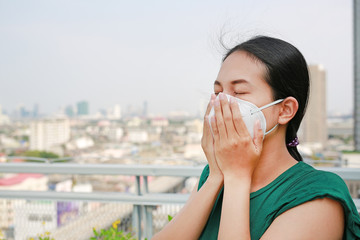 Asian woman wearing a protection mask against PM 2.5 air pollution in Bangkok city. Thailand.