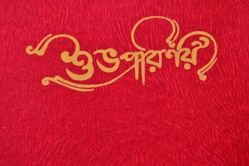 Shubha Parinoy (happy wedding) writing in bengali on a red background