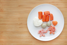 Frozen Baby Food Homemade And Raw Food In White Plate, Sliced Carrot Egg And Rice For Mashed On Wooden Board.