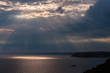 © ancamilushev - Sun rays through storm clouds at sea