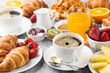 Continental breakfast table with coffee, orange juice, croissants