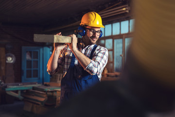 Canvas Print - Carpenter working with circular saw at carpentry workshop 