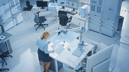 Aufkleber - Team of Industrial Robotics Engineers Working on Computers, Talking and Using Machine Learning Technique to Manipulate and Program it to Pick Up and Move Metal Component. Top Down Above Shot
