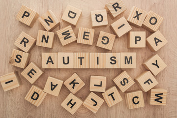 Wall Mural - top view of autism lettering made of wooden blocks among another letters