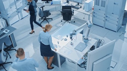 Aufkleber - Team of Industrial Robotics Engineers Working on Computers, Talking and Using Machine Learning Technique to Manipulate and Program it to Pick Up and Move Metal Component. Top Down Above Shot
