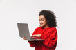 © Drobot Dean - Smiling african woman in red sweater using laptop computer