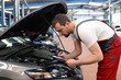 © industrieblick - Check am KFZ durch Automechaniker in einer Werkstatt // Check at the motor vehicle by a car mechanic in a workshop