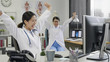 © PRPicturesProduction - Happy successful female asian doctors celebrate victory in hospital office success of patient treatment. young girls medical staff workers sitting at working desk raised arms together cheerful smile