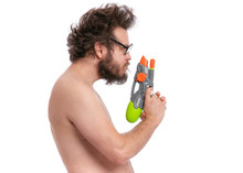 Crazy Bearded Man With Funny Haircut In Eyeglasses, Ready For Fun At Sunny Beach. Happy And Silly Tourist, Isolated On White Background. Cheerful Naked Man Holding Water Gun.