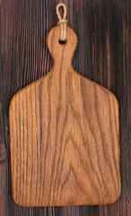 Wall Mural - Wooden oak cutting board on a old rustic surface, top view, close up.