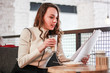 © Yaroslav - Portrait of a pretty young business lady working in a cafe. Papers, telephone conversations, laptop and coffee in the coworking area