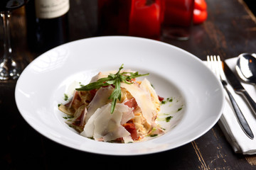 Canvas Print - pasta with parmesan and prosciutto on a white plate