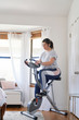 © Inti St. Clair - Woman exercising on stationary bicycle