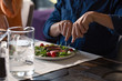 © ZoneCreative - Midsection of man having food at dining table