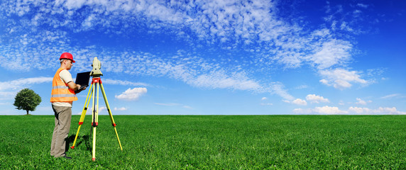 Surveyor on green field