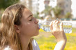 © Anna - Beautiful teen girl drinks clean water from a plastic bottle on a hot summer day. Selective focus