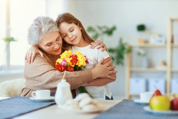 Wall Mural - Happy mother's day! granddaughter gives flowers and congratulates an grandmother on holiday .