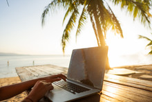 Girl Freelancer Working On The Sea At Sunset With A Computer
