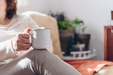 Close up of elderly woman hands while holding a cup of coffee