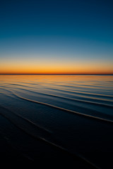 Vivid amazing sunset in Baltic States - Dusk in the sea with horizon illuminates by the sun