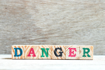 Wall Mural - Alphabet letter block in word danger on wood background