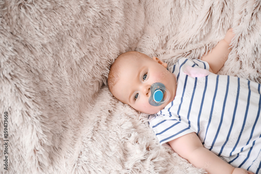 Adorable baby girl lying on soft plaid