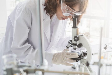 Wall Mural - a young asian woman scientist working in laboratory with test tube microscope and solutions.