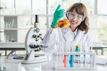 Wall Mural - a young asian woman scientist working in laboratory with test tube microscope and solutions.