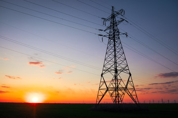 Silhouette High voltage electric towers at sunset time. High-voltage power lines. Electricity distribution station