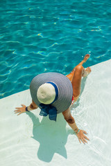 Poster - Woman relaxing in swimming pool at spa resort. r