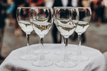 Wall Mural - champagne and wine glasses on tray at luxury wedding reception at restaurant.  waiter serving drinks among guests at stylish celebration. luxury life concept. space for text