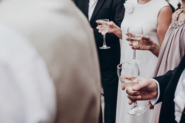 Wall Mural - people toasting with champagne and wine glasses in hands at luxury wedding reception at restaurant. cheering at stylish celebration. luxury life concept. space for text